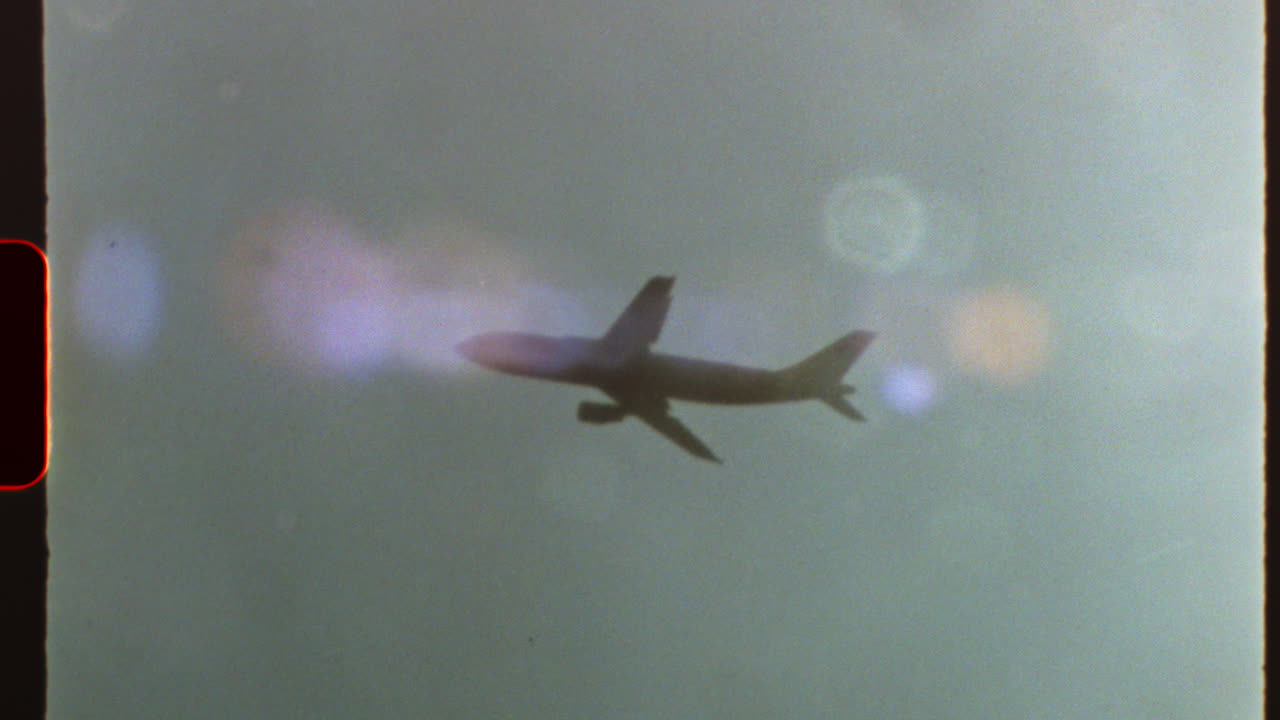 Filmed on super 8 film - passenger airplane soaring through pristine blue sky, capturing nostalgic journey with authentic 8 mm film aesthetic and distinctive light leaks