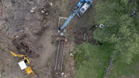 flight with a drone of the work of a plant material crusher supported in its work by two machines we see how it crushes and leaves the material on a conveyor belt all in slow motion