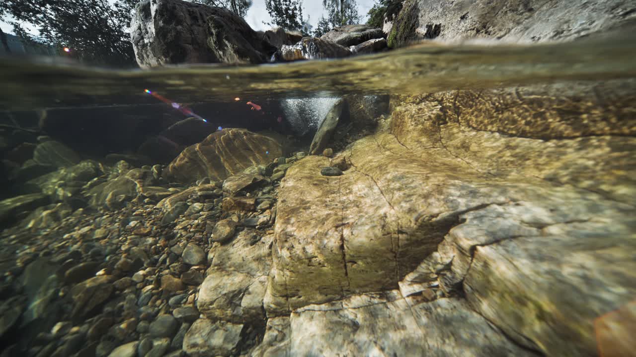 An enchanting over-under view unveils the river's rocky terrain and shores