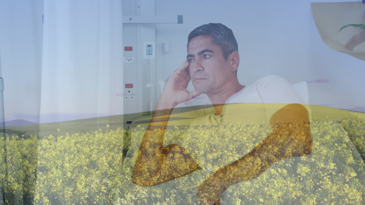 Sitting in hospital room, man watching animation of yellow field landscape