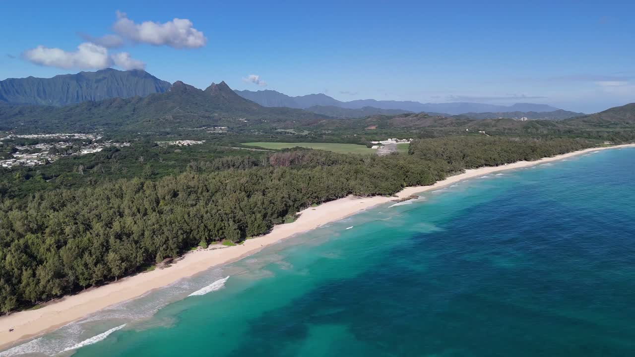 Filmato di un drone in 4K di un bellissimo oceano blu cristallino sulla spiaggia di Waimanalo che mostra il monte Olomana e i Koolau a Oahu, nelle Hawaii.