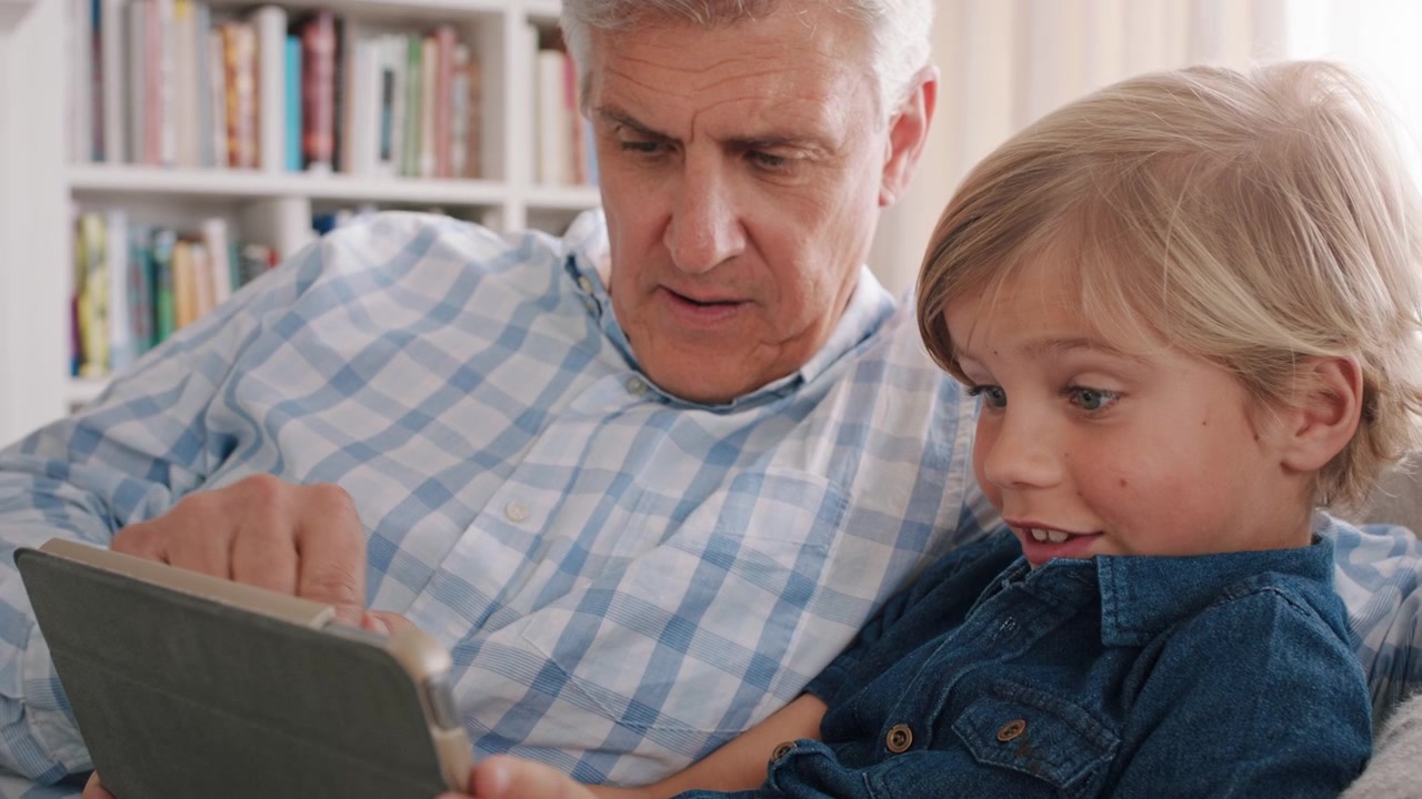 Grandfather and Grandson Using a Digital Tablet Together at Home