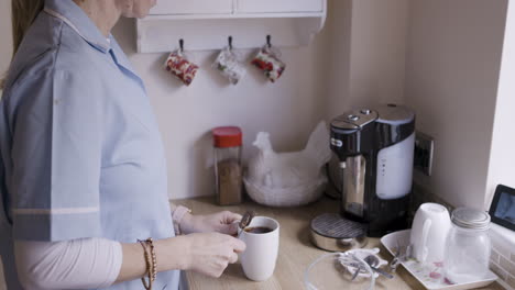 woman stirring coffee in the kitchen