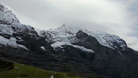 aerial view of eiger north face in the bernese alps, switzerland, covered with glaciers, snow, and steep rock cliffs rising into the clouds
