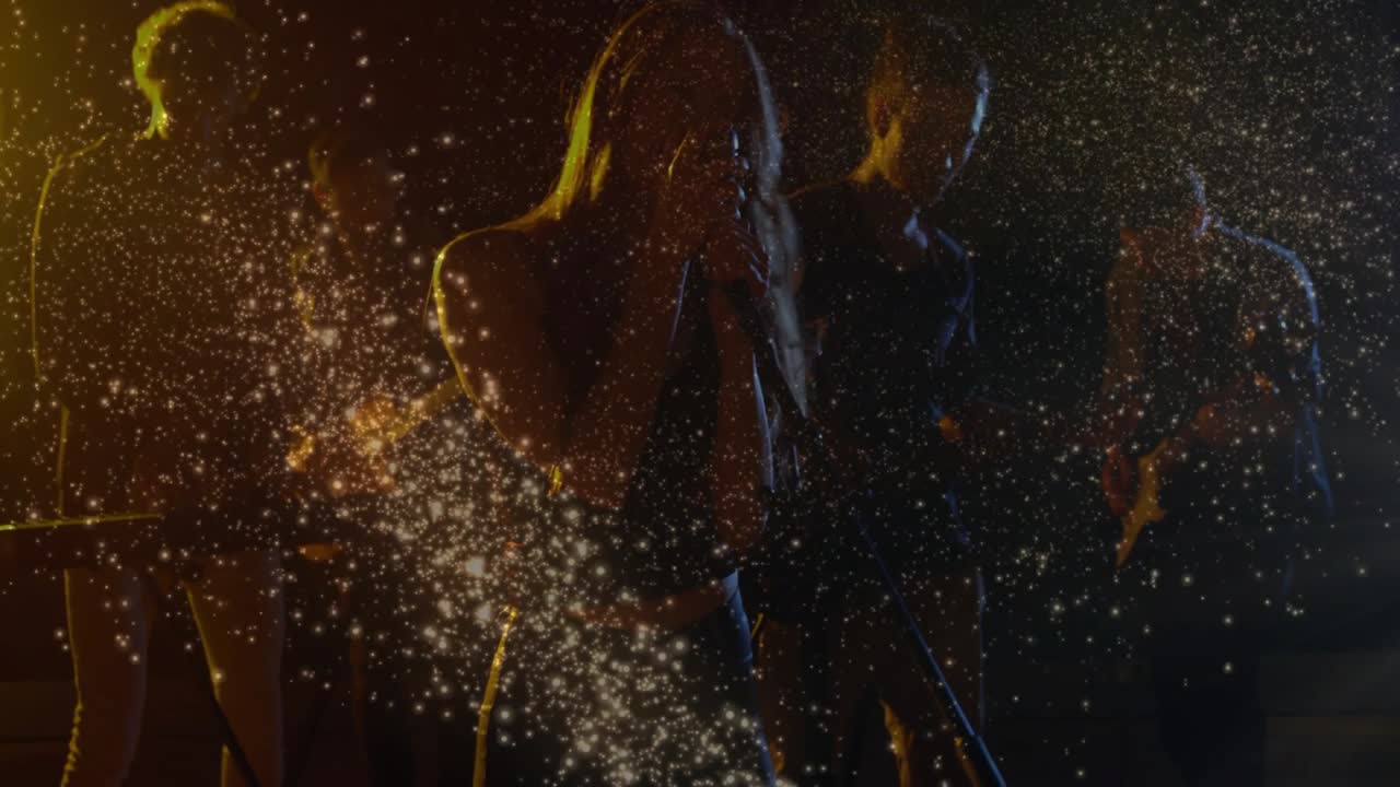 Video verticale: Il cantante solista canta mentre la luce a destra emette un arco di scintille, illuminando la band per la musica.