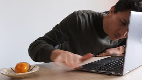 man cleaning his laptop computer from dust and hairs
