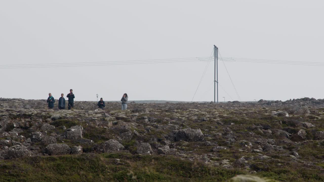 A group of people gathered in the rocky Iceland landscape to witness the eruption of Grindavik volcano in Sundhnúkur crater.