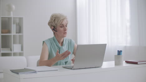 woman is conducting online training by internet talking by videocall on notebook working from home e-learning