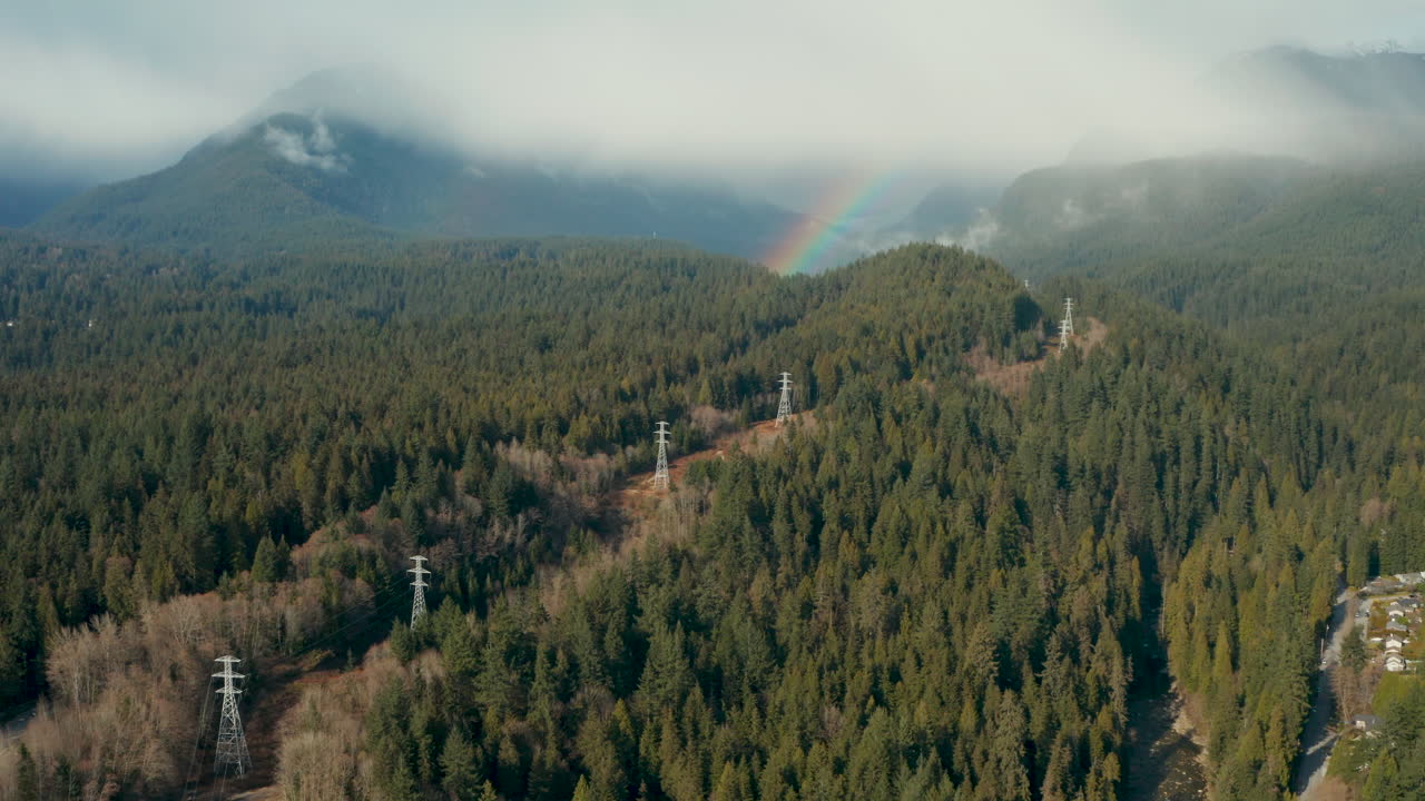 Flygfoto mot en regnbåge i den fantastiska bergsskogen runt North Vancouver, British Columbia