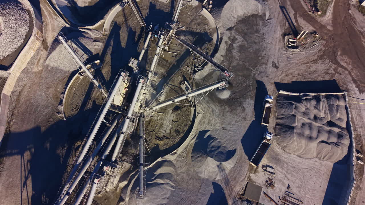 Industrial landscape showcasing machinery and raw materials in a construction site under bright sunlight during daytime hours