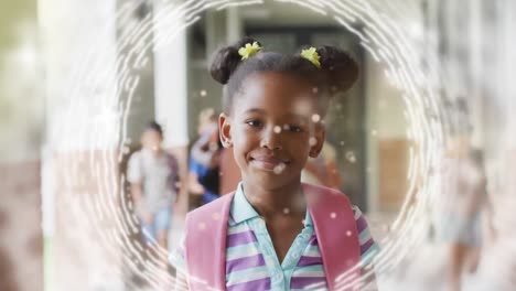 Animation-of-lights-and-data-loading-over-happy-african-american-schoolgirl-in-school-corridor