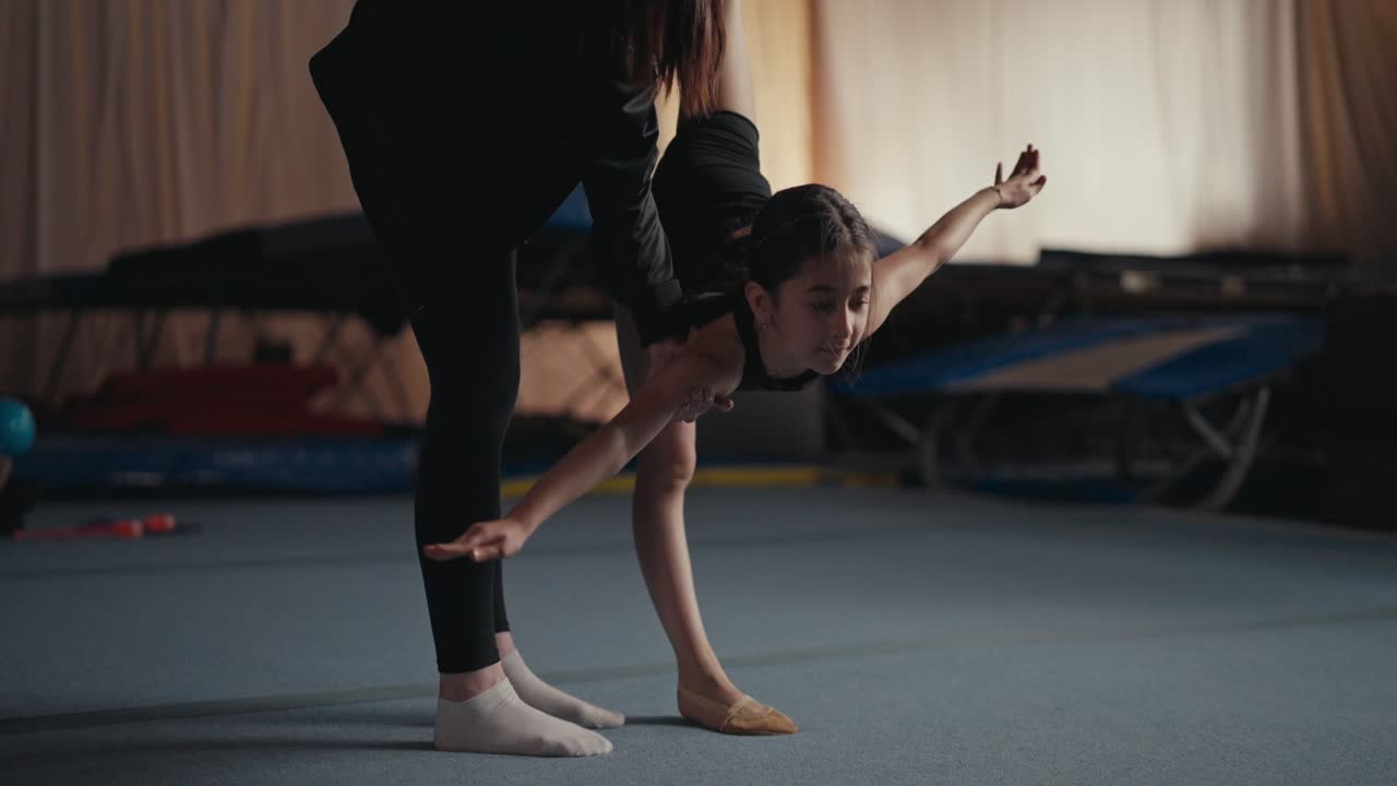 Giovane ginnasta che si allena con il suo allenatore in palestra.