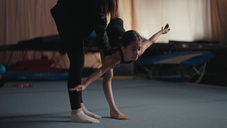 young gymnast training with her coach in the gym