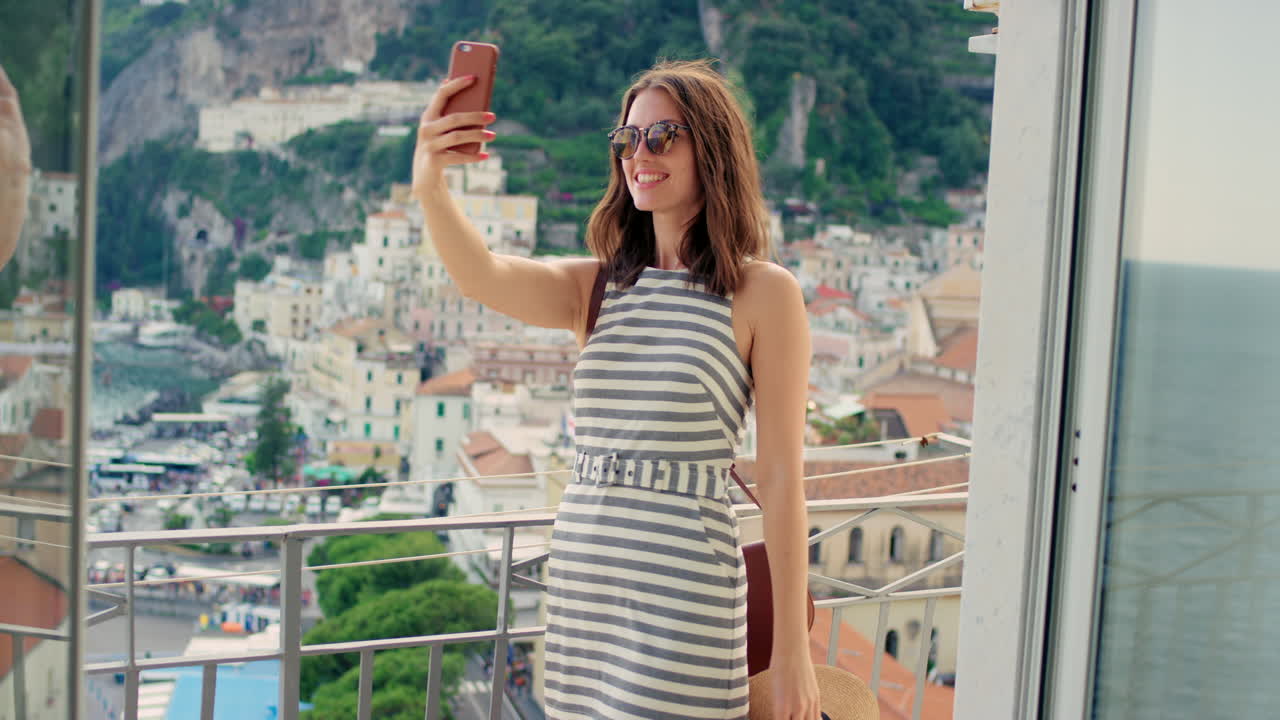 mujer tomando un selfie en un balcón con una hermosa vista