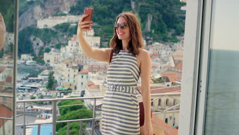 mujer tomando un selfie en un balcón con una hermosa vista