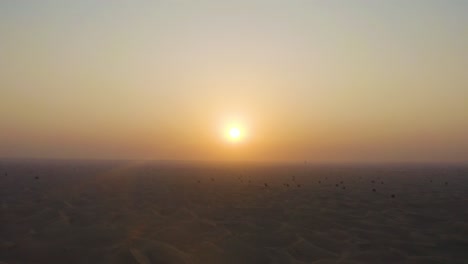 Toma-Aérea:-Volando-Sobre-Las-Dunas-De-Arena-Del-Desierto-Hacia-La-Puesta-Del-Sol