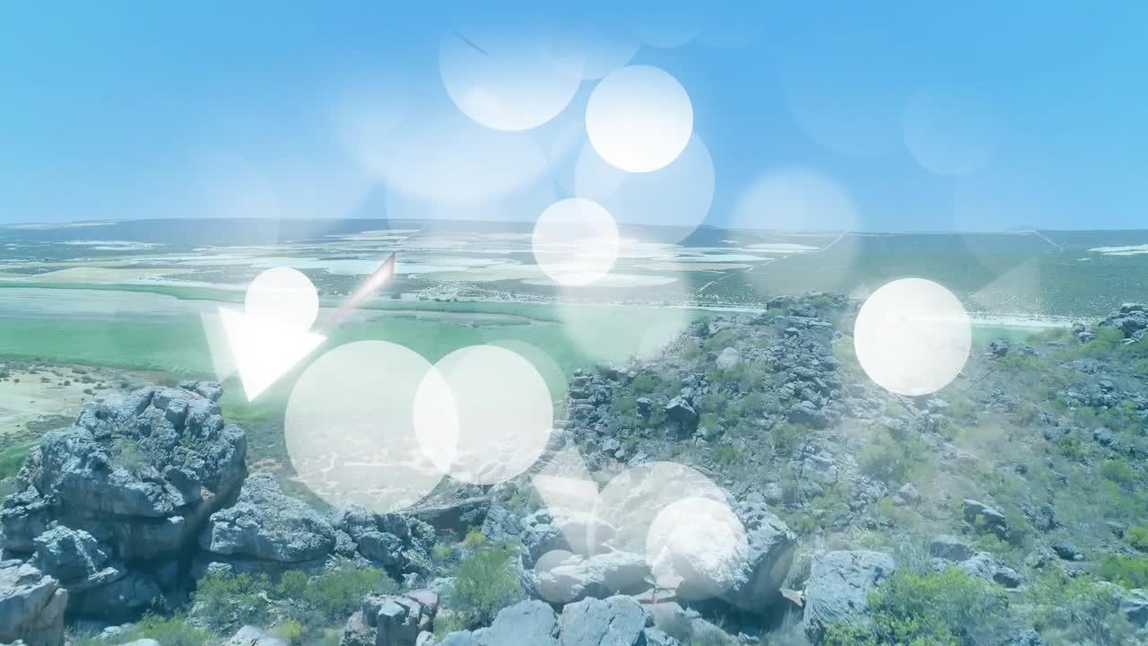 Graphic shapes appearing from left center drifting over ridge with drone panning revealing plains