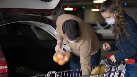 tracking video of couple packing groceries during a pandemic