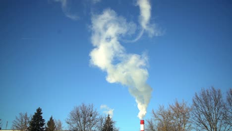 smoke from factory chimney against blue sky