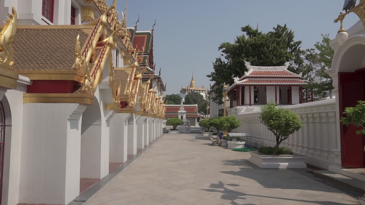 Slow Motion clip walking at a very popular tourist attraction and destination in the city of Bangkok in Thailand with golden mountain temple in the background