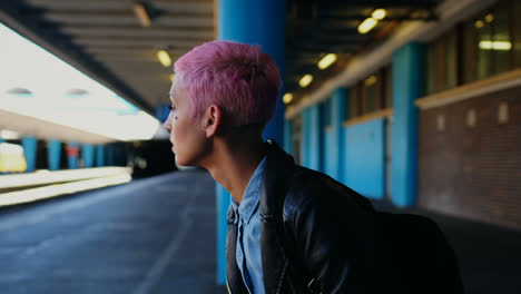 Pink-hair-woman-waiting-for-train-in-railway-station-4k