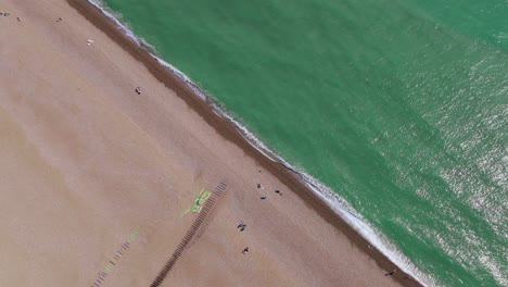 ocean waves, relaxing beach visitors, sandy shoreline, birdseye aerial