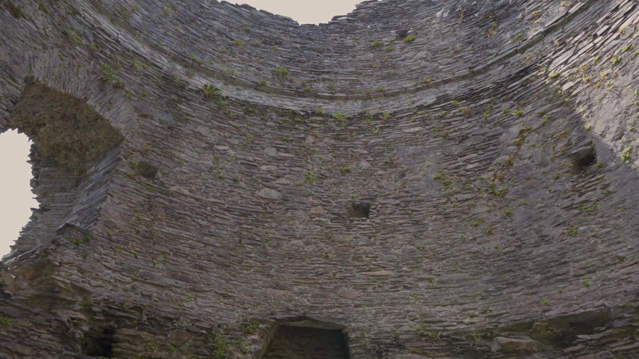 Vista detalhada do interior da torre do castelo de Dolbadarn, câmera movendo-se para cima mostrando os detalhes internos das ruínas de alvenaria da torre. 4k 30fps.