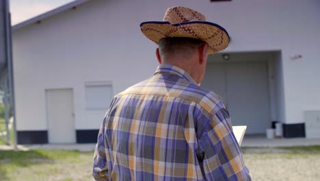 Landwirt-überprüft-Einige-Daten-Aus-Der-Zwischenablage-Auf-Dem-Bauernhof