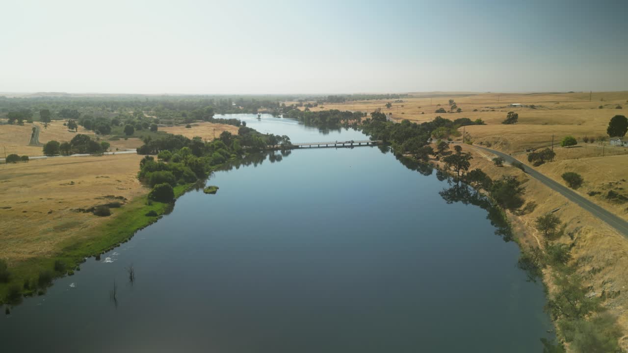 Aerial View of a Calm River and Bridge in a Rural Landscape