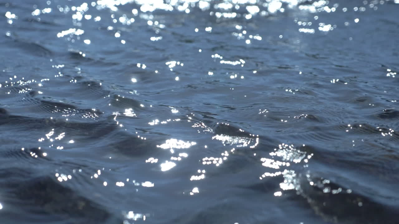 Blue water with small waves and ripples in slow motion