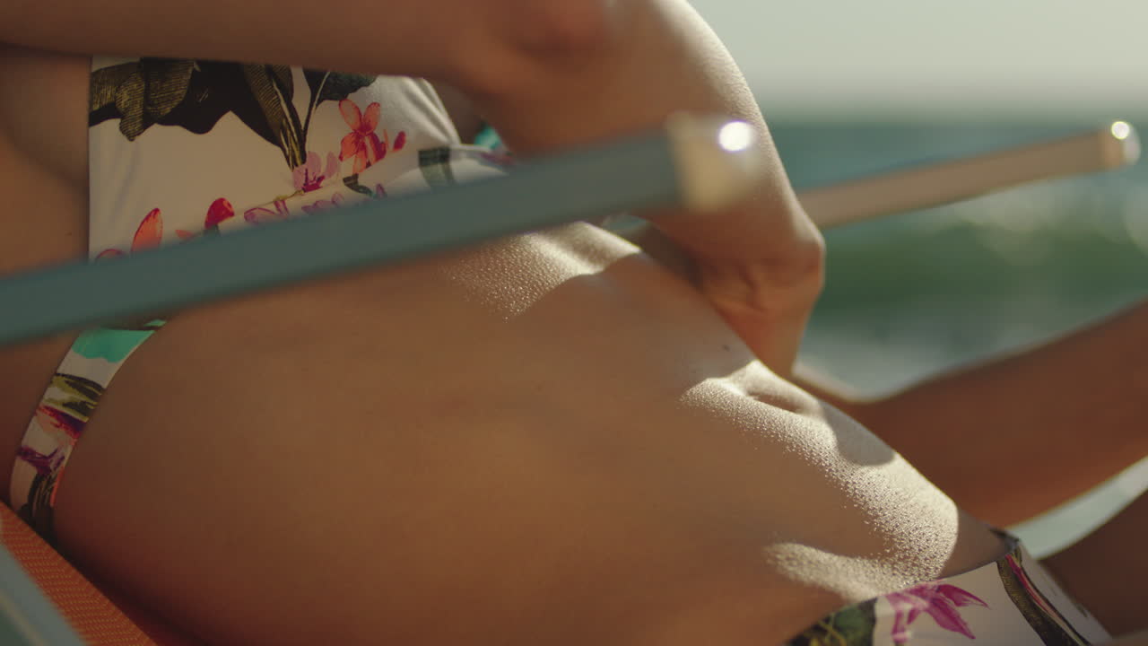 mujer aplicando protector solar en la playa