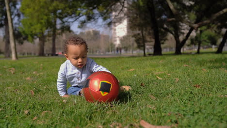 boy playing with ball, trying to rise it up, biting it