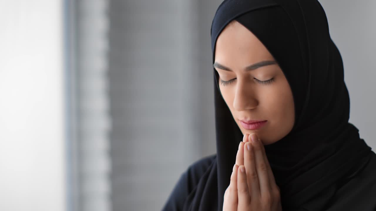 Donna musulmana obbediente con hijab che prega Allah e il profeta Maometto. Primo piano ripreso con telecamera RED 4k