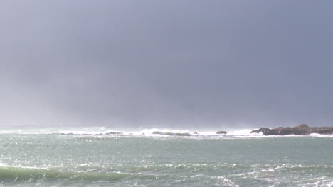 ocean waves and rocks on a cloudy day