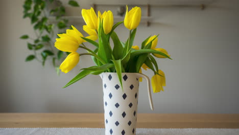 faded yellow tulips in a flower vase reviving back to life