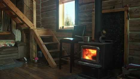 interior log cabin with fireplace stove burning brightly