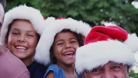 Portrait-Of-Multi-Generation-Hispanic-Family-Relaxing-In-Garden-At-Home-Together-At-Christmas