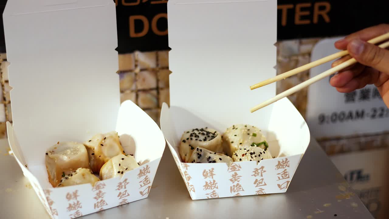 Chopsticks picking dumplings from a box