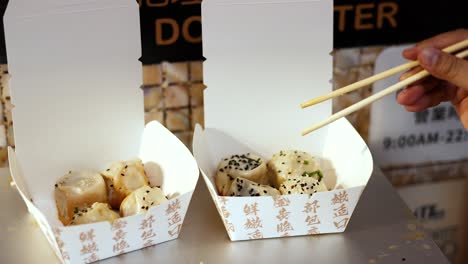 chopsticks picking dumplings from a box