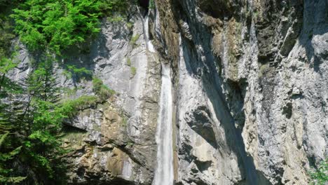 a view of bergli stüber waterfall on sheer rock walls in glarus sud, switzerland