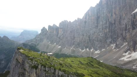casa en una gran cresta en las montañas rocosas cerca de alleghe y refugio tissi en una tarde soleada