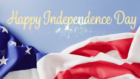 animation of happy independence day text in sparkling gold over flag of america and blue sky