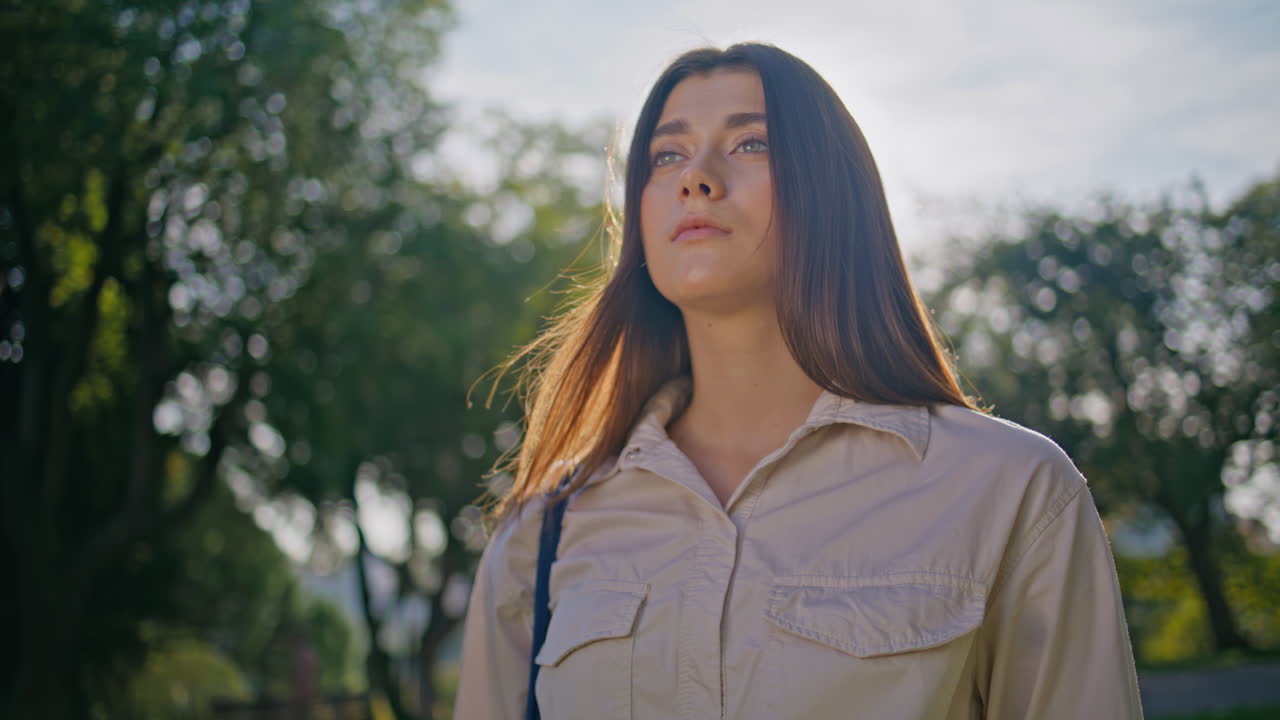 Primer plano de mujer pensativa de pie bajo el sol. Hermosa mujer disfrutando de la naturaleza soleada.
