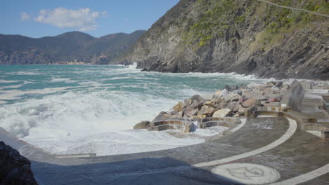 Ondas-Fuertes-Rompiendo-Contra-Las-Rocas-En-La-Costa-De-Italia-Creando-Un-Rocío-De-Agua-Dramático-Y-Bronco.