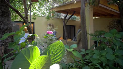 slow establishing shot of a garden patio with furniture at a villa