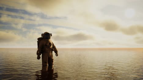 spaceman in the sea under clouds at sunset