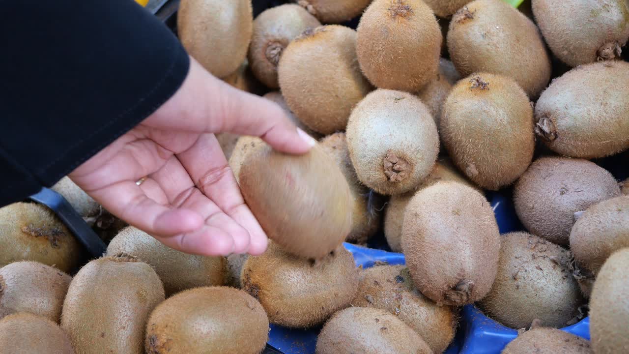 시장에서 키위 과일을 구입하는 사람