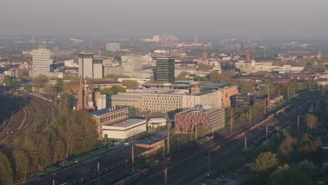 Rail line in Bochum within the Ruhr rail network, Bochum city under hazy sky, Drone shot