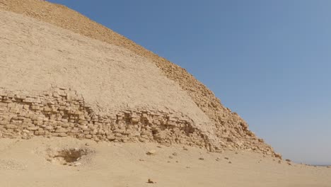 panning over sandy desert to ancient egyptian bent pyramid on sunny day, egypt