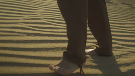 barefooted person walking in the beautiful dessert sand during a sunset